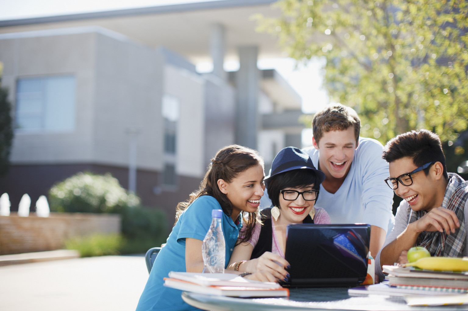 four international students in front of a laptop
