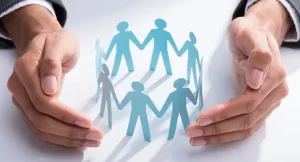 paper people holding hands in a circle within a hand