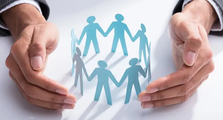 paper people holding hands in a circle within a hand